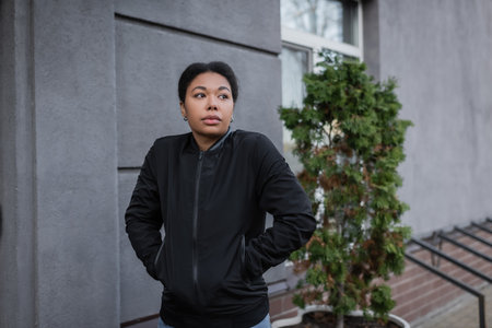 multiracial woman with mental problem standing near building on urban streetの写真素材