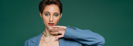 young woman with short hair posing in blue jacket on turquoise green background, banner