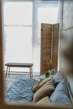 bedside bench and folding screen in near bed and bedside table bedroomの写真素材