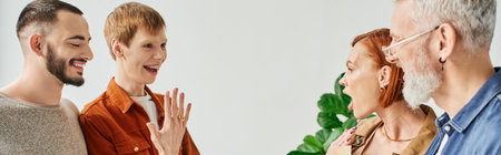 overjoyed gay man showing wedding ring to amazed parents near boyfriend at home, bannerの写真素材