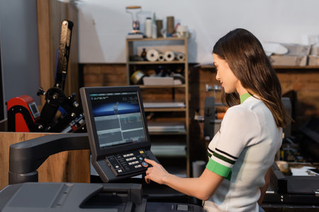 pretty publisher pressing button on panel while working in print center