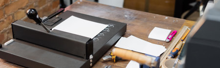 high angle view of paper on top of paper trimmer machine in modern print center, banner