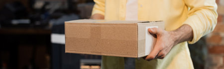 cropped view of publisher holding carton box in print center, bannerの写真素材
