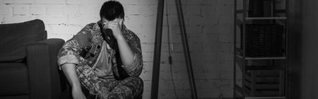 Black and white photo of military veteran suffering from emotional distress at home, bannerの写真素材