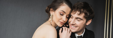 portrait of young brunette bride in luxurious earrings with pearls sitting with closed eyes and...