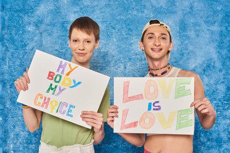 positive gay activists smiling while holding placards with love is love and my body my choice words...