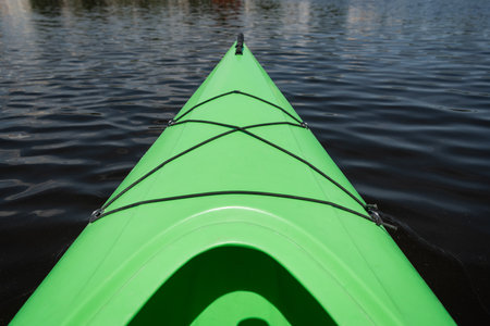 high angle view of front part of bright green sportive kayak on calm water surface in summer, water recreation, vacation destination, summer gateaway, conceptの写真素材