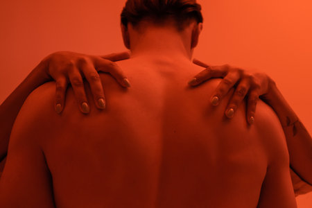 young and shirtless man with muscular back near passionate african american woman embracing his...