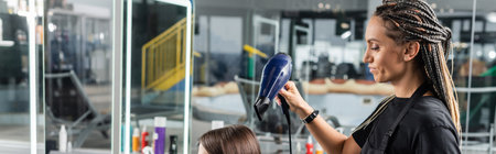 salon blow dry, professional hairdresser with round brush and hair dryer styling hair of female customer, brunette woman with short hair, beauty salon, hair volume, blowout, bannerの写真素材