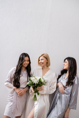 happy bride with white flowers, diverse bridesmaids, bridal bouquet, cultural diversity, friendship goals, brunette and blonde women, bridal shower, smile and joyの写真素材