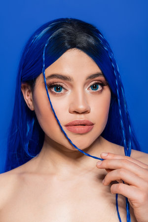 vibrant youth, self expression, portrait of young woman with dyed hair posing on blue background,...