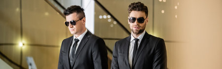 security management of luxury hotel, two handsome men in formal wear and sunglasses, bodyguards on...