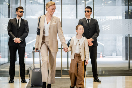 personal security service, two bodyguards in formal wear and sunglasses standing near hotel...
