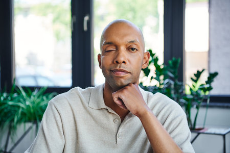 professional headshots, man with ptosis, eye syndrome, bold african american businessman looking at camera, dark skinned office worker with myasthenia gravis disease, diversity and inclusionの写真素材