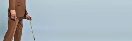 real people, cropped view of african american man leaning on walking cane on grey background, dark...