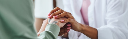partial view of african american woman holding hands of tattooed female friend while supporting and...