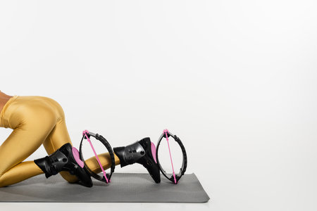 cropped view of woman in active wear exercising on fitness mat in  jumping shoes, toned bodyの写真素材
