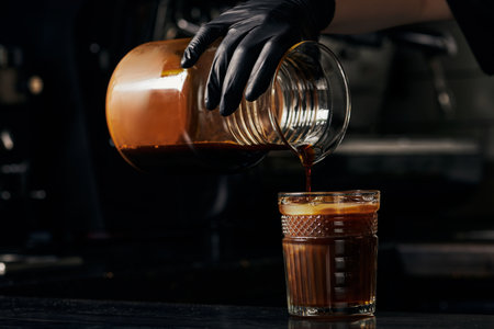 pouring espresso into orange juice, refreshing beverage, coffee, barista making bumblebee drinkの写真素材