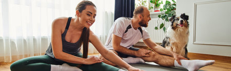 Smiling woman exercising with boyfriend near border collie at home, banner