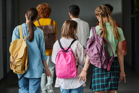 back view of schoolkids walking in hallway of school between classes, teen students, back to schoolの写真素材