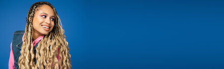 banner, pretty african american woman with dreadlocks and long hair looking away on blue backgroundの写真素材