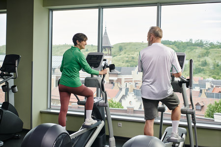 active seniors, positive woman looking at elderly man, exercising together, senior couple, sport