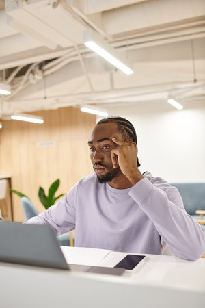 focused african american man using laptop, working on startup project, ideas, creativity, brainstorm