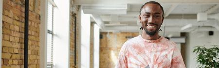 happy african american man looking at camera in modern open space, coworking, startup, bannerの写真素材