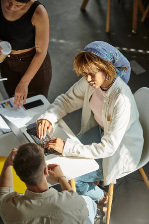 african american woman using laptop, working on startup ideas with colleagues in coworkingの写真素材