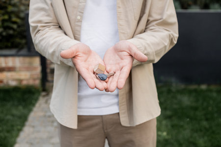 cropped view of real estate broker with key from new house in hands outdoors