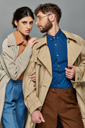 outerwear, couple in trench coats, autumn fashion, stylish man and woman, grey background, fallの写真素材