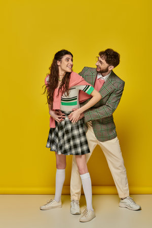 cheerful couple having fun, man in glasses and young woman looking at each other, hug, students