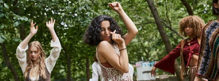 positive multiracial woman dancing near blurred girlfriends outdoors in retreat center, banner