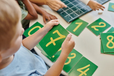 top view of boy holding number seven card, learning how to count in Montessori school, studyの写真素材