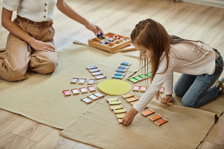 montessori school, girl near color educational game in shape of sun, teacher, early educationの写真素材