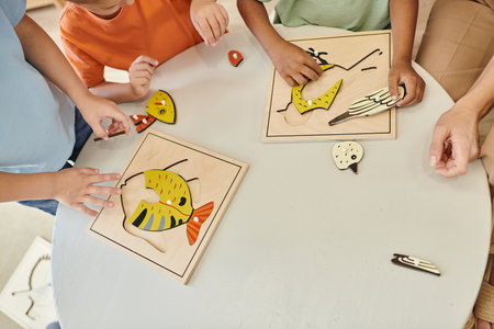 top view, cropped interracial kids playing with didactic montessori material in school, puzzleの写真素材