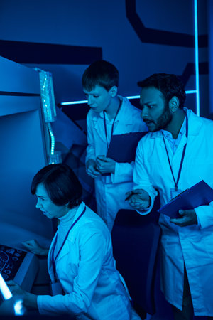 Exploring Tomorrow: Three Scientists Collaborate Near Futuristic Computer in Science Centerの写真素材