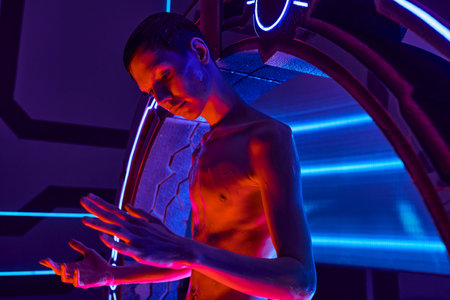 otherworldly creature, humanoid alien looking at hands near innovative equipment in science centerの写真素材