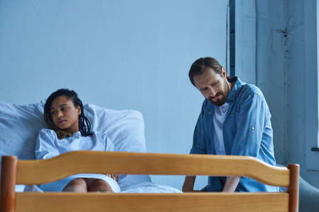miscarriage, man sitting near depressed african american woman, grief, hospital bed, private ward