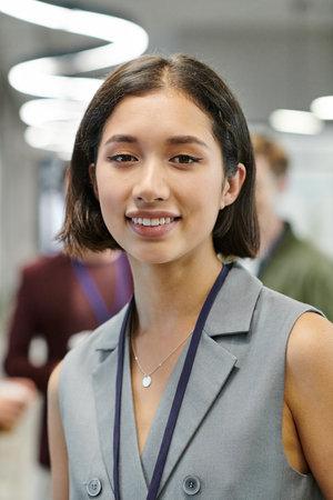 portrait of joyful brunette businesswoman looking at camera in contemporary office
