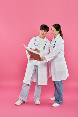 oncologists, female doctors looking at folder, medical records, breast cancer awareness, campaignの写真素材