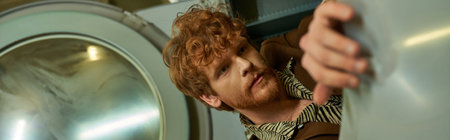 fashionable young man posing in washing machine in public laundry, bannerの写真素材