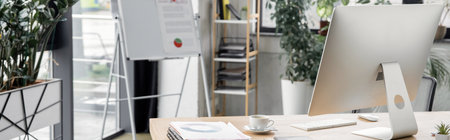flip chart, work desk with computer monitor, documents and coffee cup, modern office, bannerの写真素材