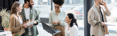 happy interracial business people using devices while planning startup project in coworking, banner