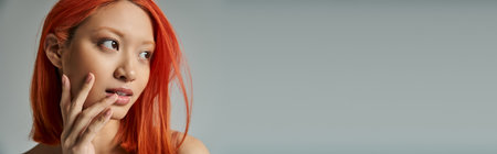 asian beauty, young woman with red hair and natural makeup looking away and touching cheek, bannerの写真素材