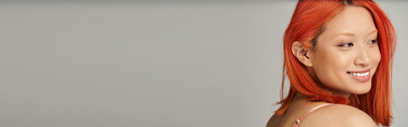 alluring young asian woman with perfect skin and natural makeup smiling on grey background, bannerの写真素材