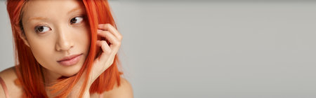 close up of charming young asian woman with perfect skin  daydreaming on grey background, bannerの写真素材