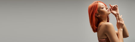 dreamy asian woman with closed eyes standing in slip dress on grey background, feminine grace bannerの写真素材