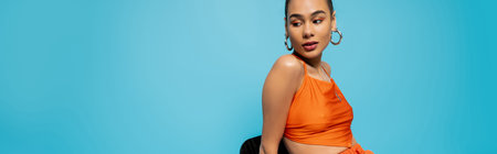 gorgeous african american in bright outfit with hoop earrings sitting on tall chair, bannerの写真素材