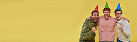 multicultural happy friends in casual attire with birthday hats looking at camera, birthday, bannerの写真素材